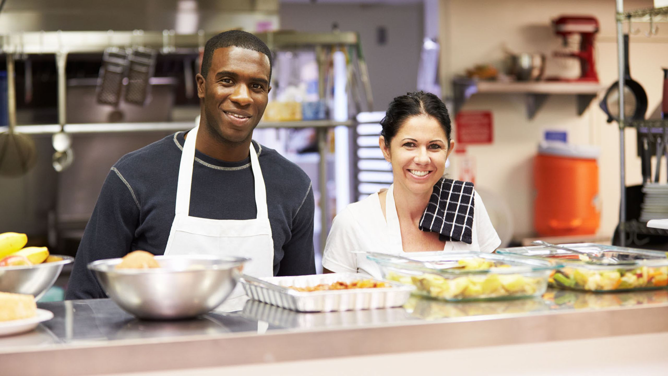 Man and woman in a food pantry preparing food