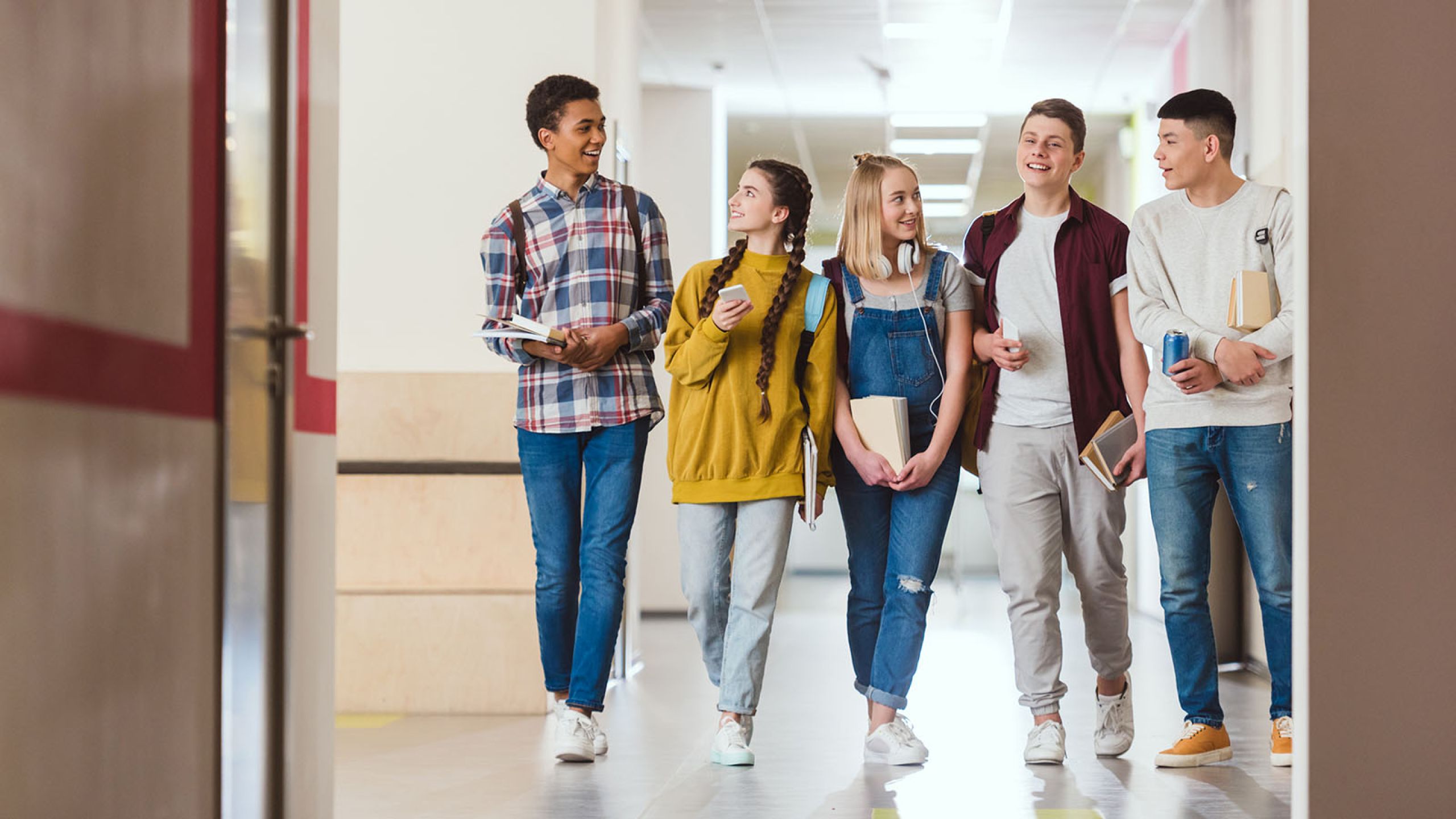 Children walking shoulder to shoulder in a hallway